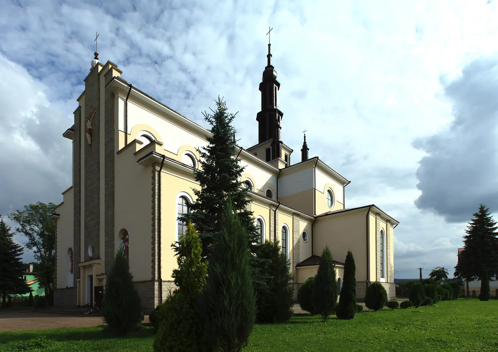 Bryła kościoła w Dubiecku z wieżą, sygnaturkami i rzędem okulusów nad łukowymi oknami