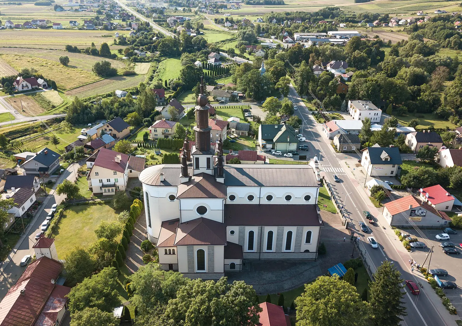 Kościół w Dubiecku z lotu ptaka, wśród zabudowy miasteczka przy głównej drodze